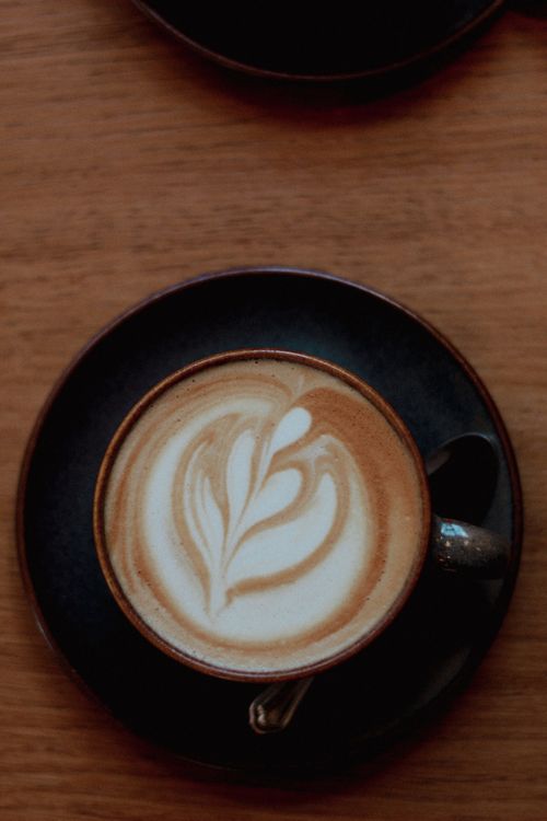 Free Captivating latte art featuring a heart motif in a creamy cup of coffee, top view shot. Stock Photo