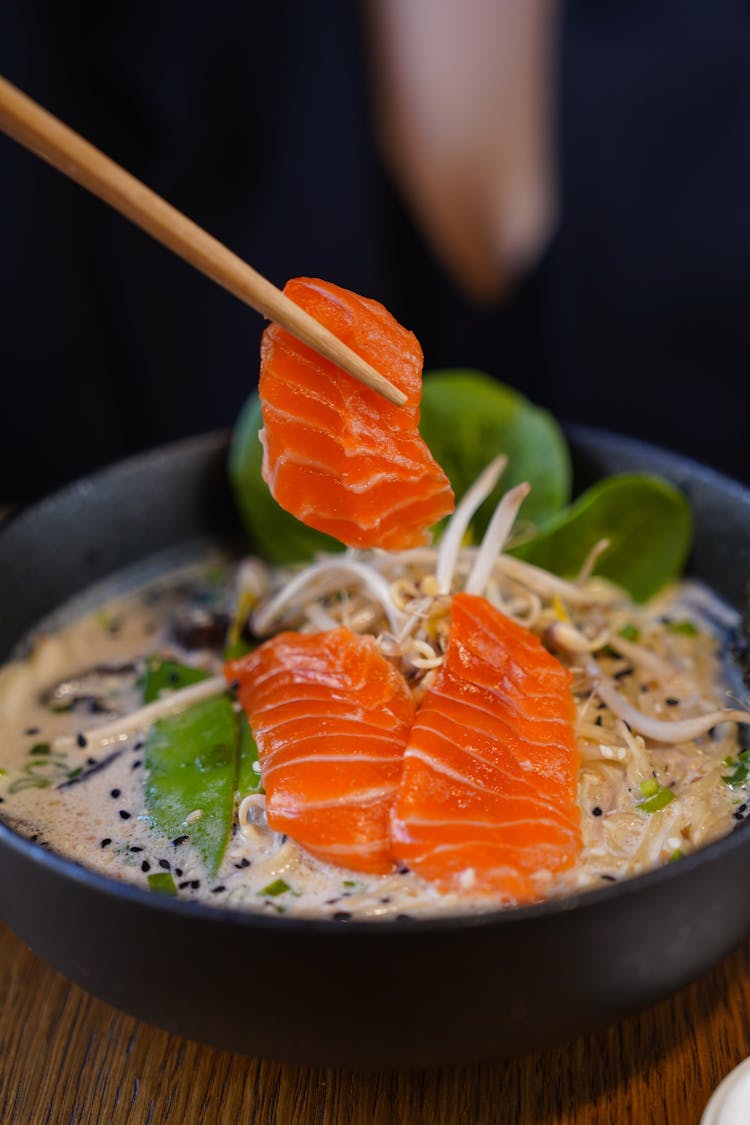 Eating Fish From Soup With Chopsticks