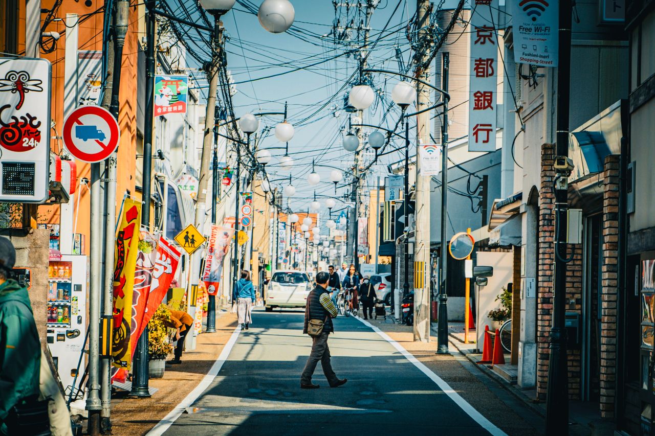 colorful urban street in kyoto with pedestrians and traditional signs