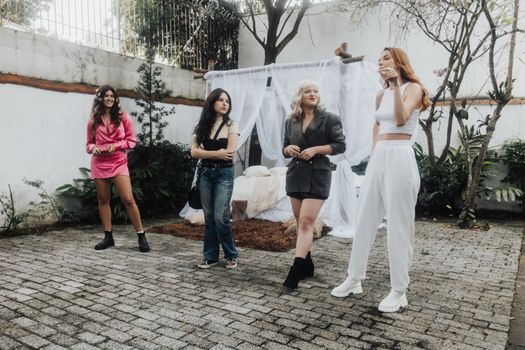 A diverse group of women models posing outdoors in stylish outfits, showcasing fashion trends.