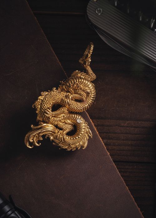 Free Intricately detailed golden dragon pendant, perfect for collectors or jewelry enthusiasts. Stock Photo