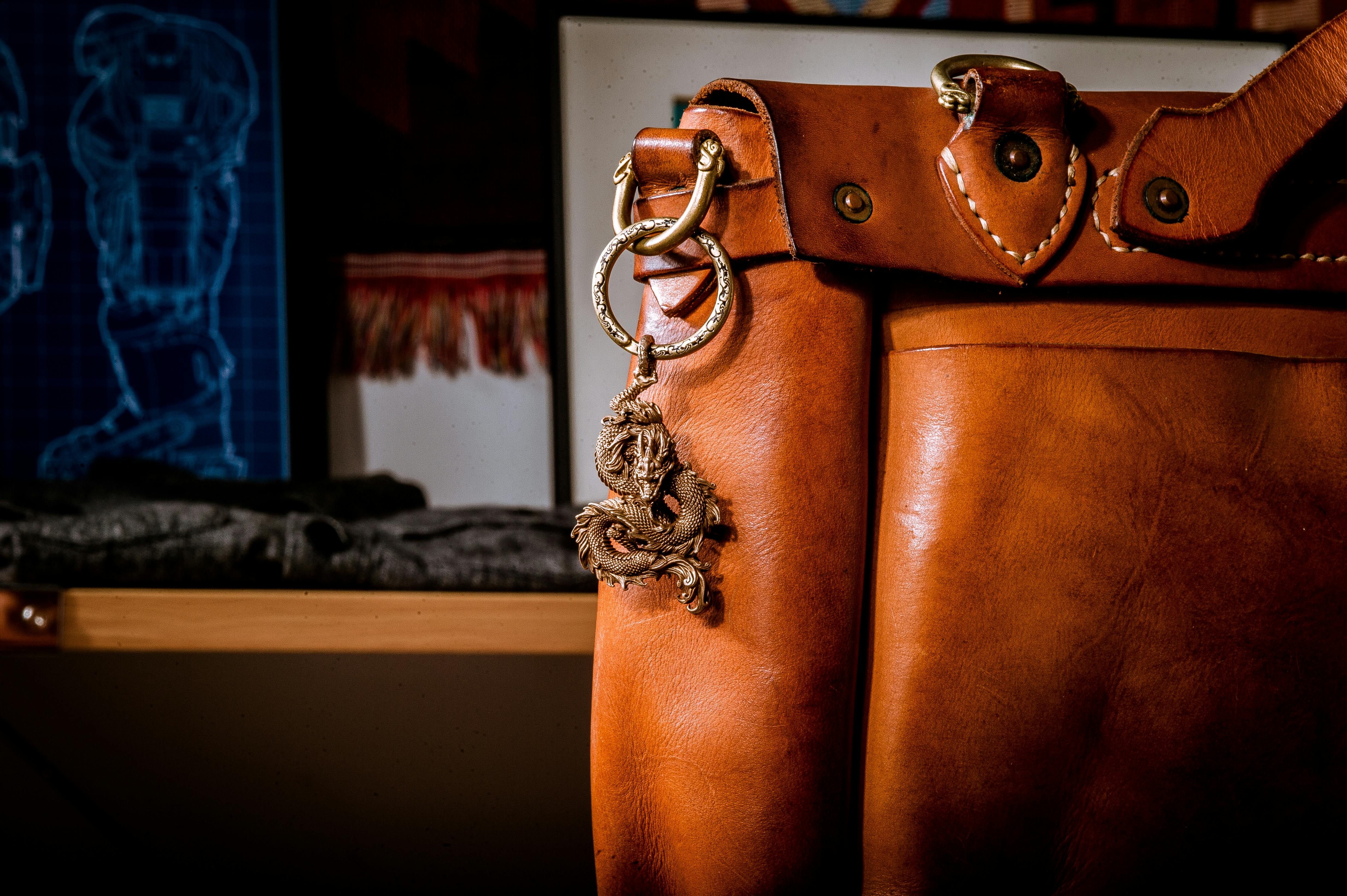 Small brown leather bag on bed · Free Stock Photo