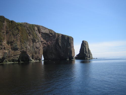 Graue Klippe Auf Blue Calm Sea Während Des Tages