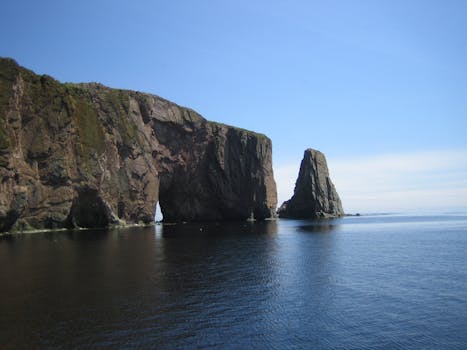 Beautiful view of Percé Rock against the clear blue sky and ocean waters in Quebec.