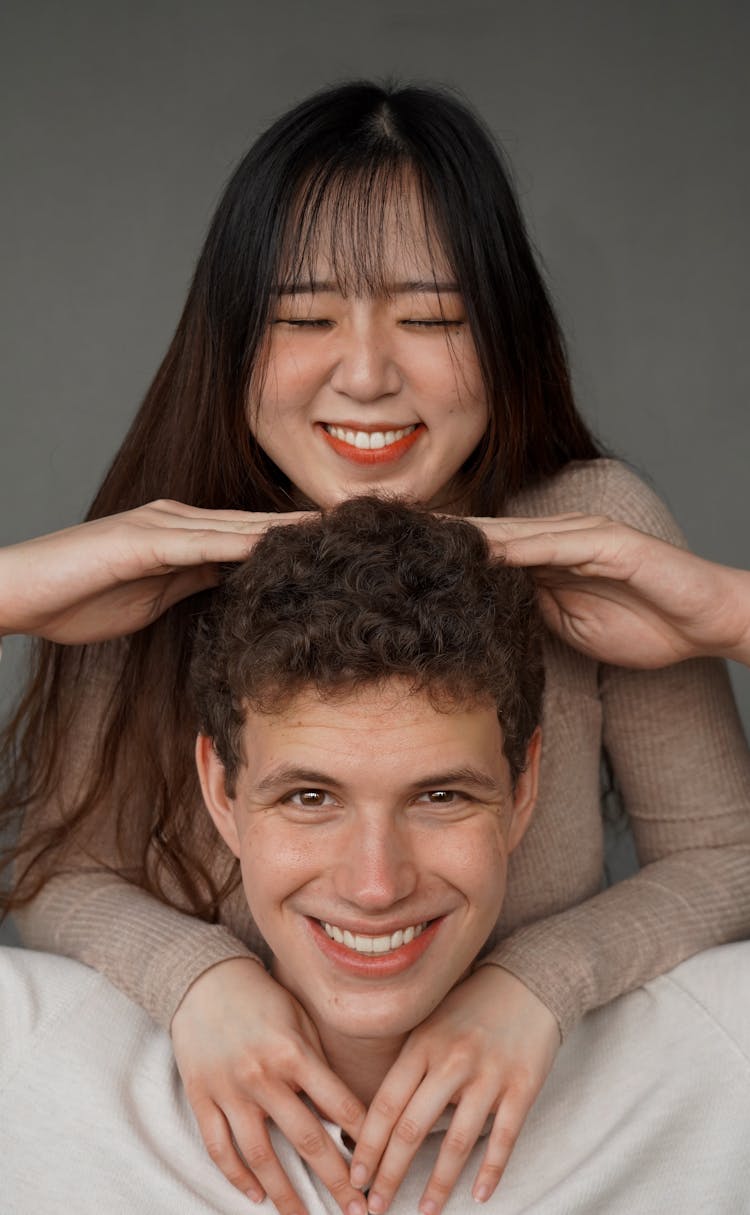 Portrait Of Smiling Interracial Couple Posing On Grey Background