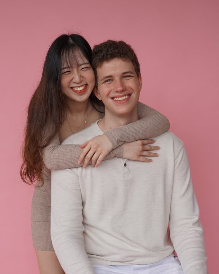 Smiling Interracial Couple Posing On Pink Background