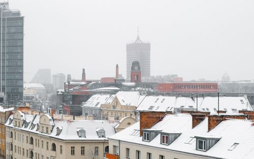Free A picturesque winter scene of snow-covered rooftops in Poznań, Poland's urban landscape. Stock Photo