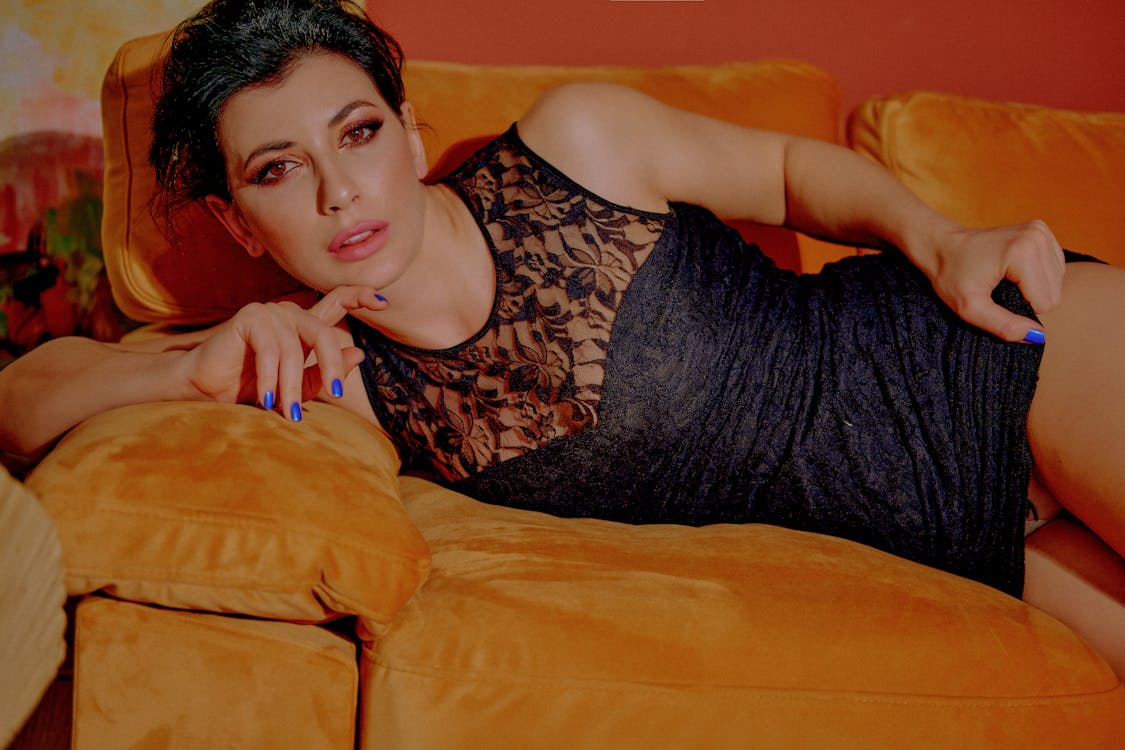Woman in a Black Lace Dress Lying on the Sofa