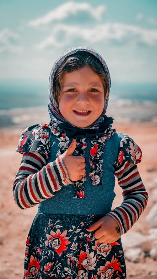 Smiling Child in Dress and Headscarf