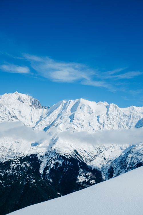 Free Breathtaking view of snow-covered mountains under a clear blue sky, perfect for winter scenery lovers. Stock Photo