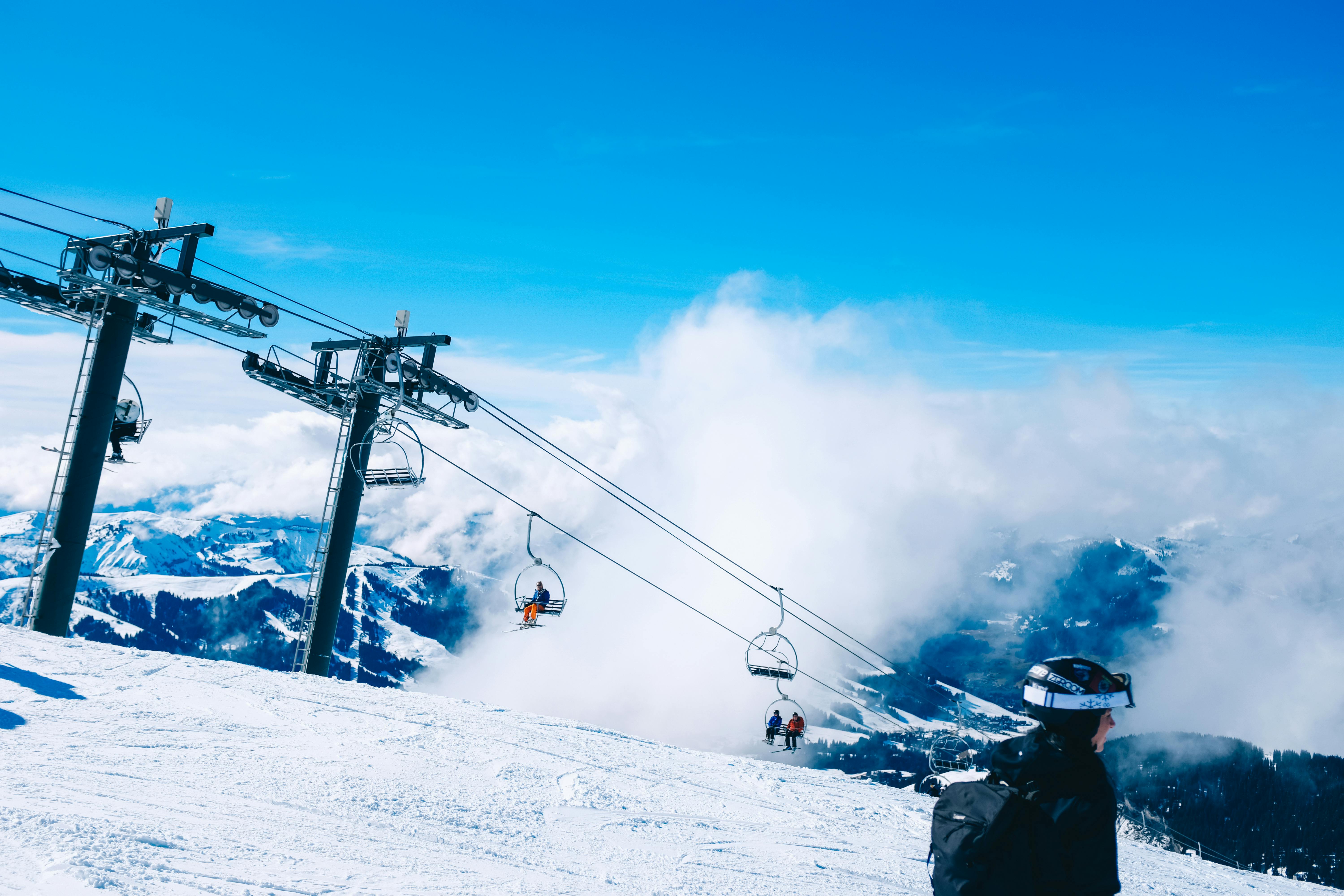 Prescription Goggle Inserts - Skiers enjoy a bright winter day on a mountain with a ski lift at an alpine resort.