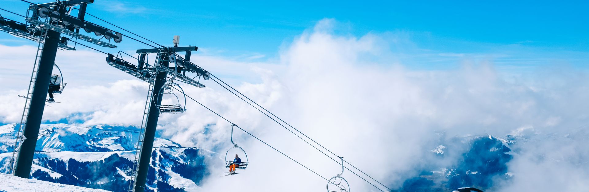 Skiers enjoy a bright winter day on a mountain with a ski lift at an alpine resort.