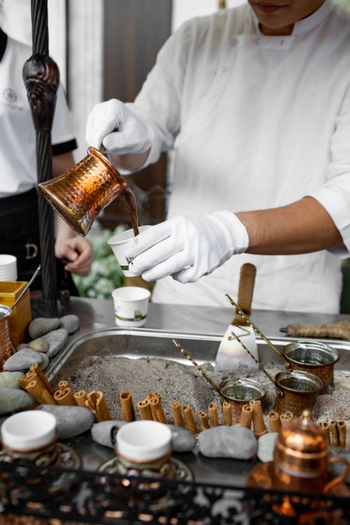 Free A person expertly pouring Turkish coffee from a cezve in a traditional setup. Stock Photo