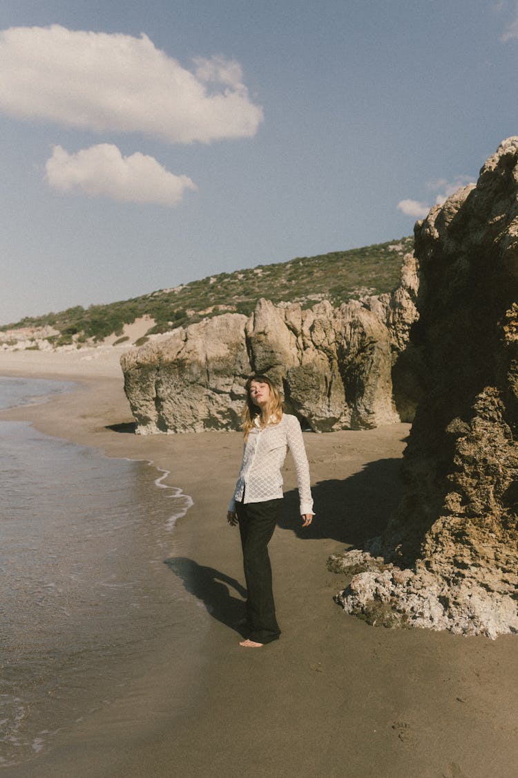 Woman Posing On Beach Near Cliffs