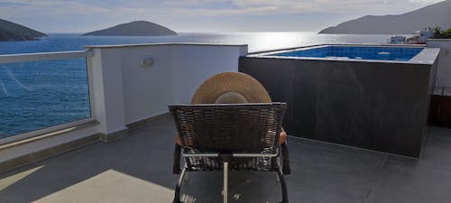 Woman Lying on a Sun Lounger and Tanning on a Terrace of a Villa by the Ocean in Arraial do Cabo, Brazil 