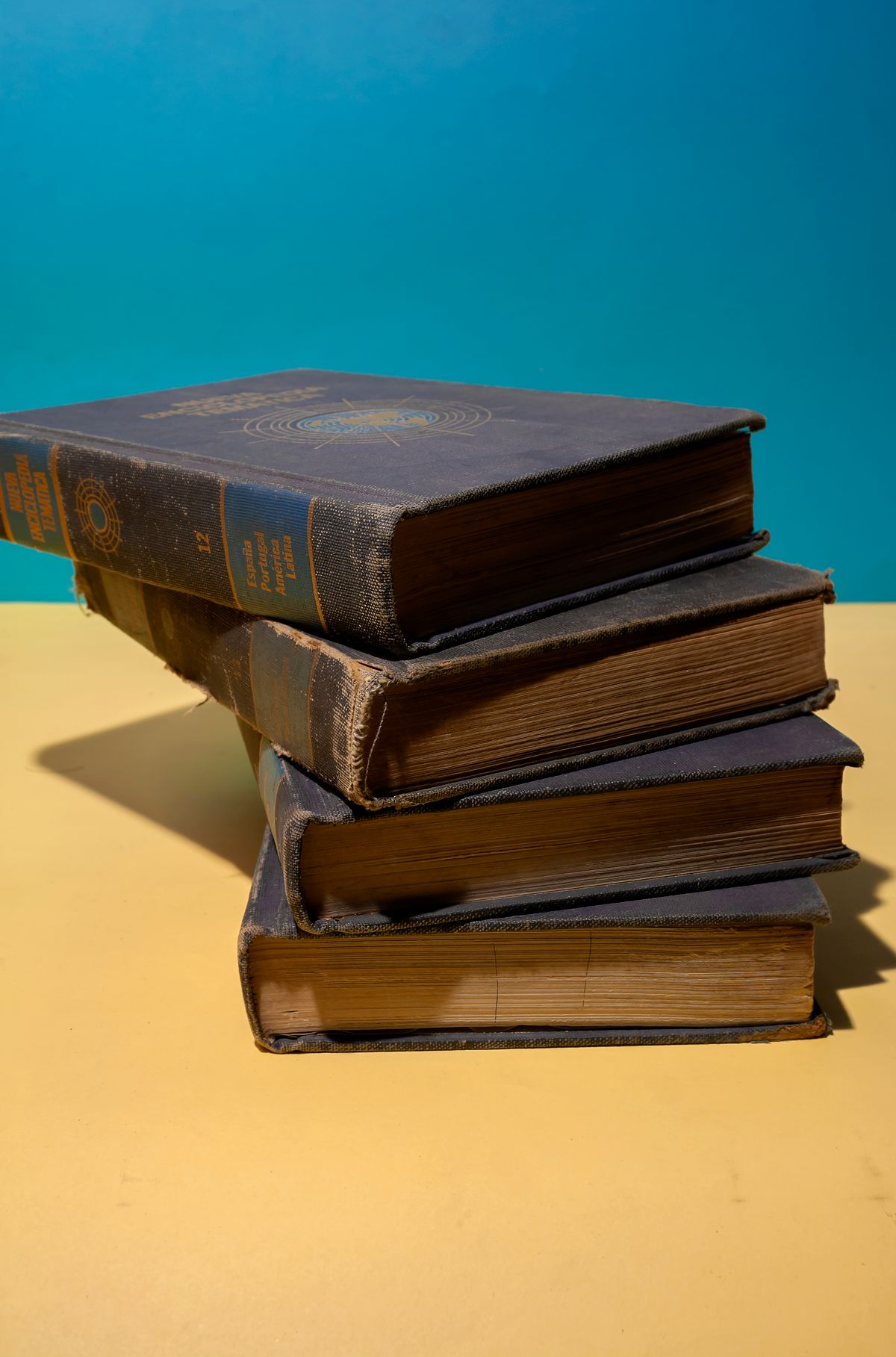 Stack of vintage books with worn covers on a table, for a light history round, trivia night party ideas