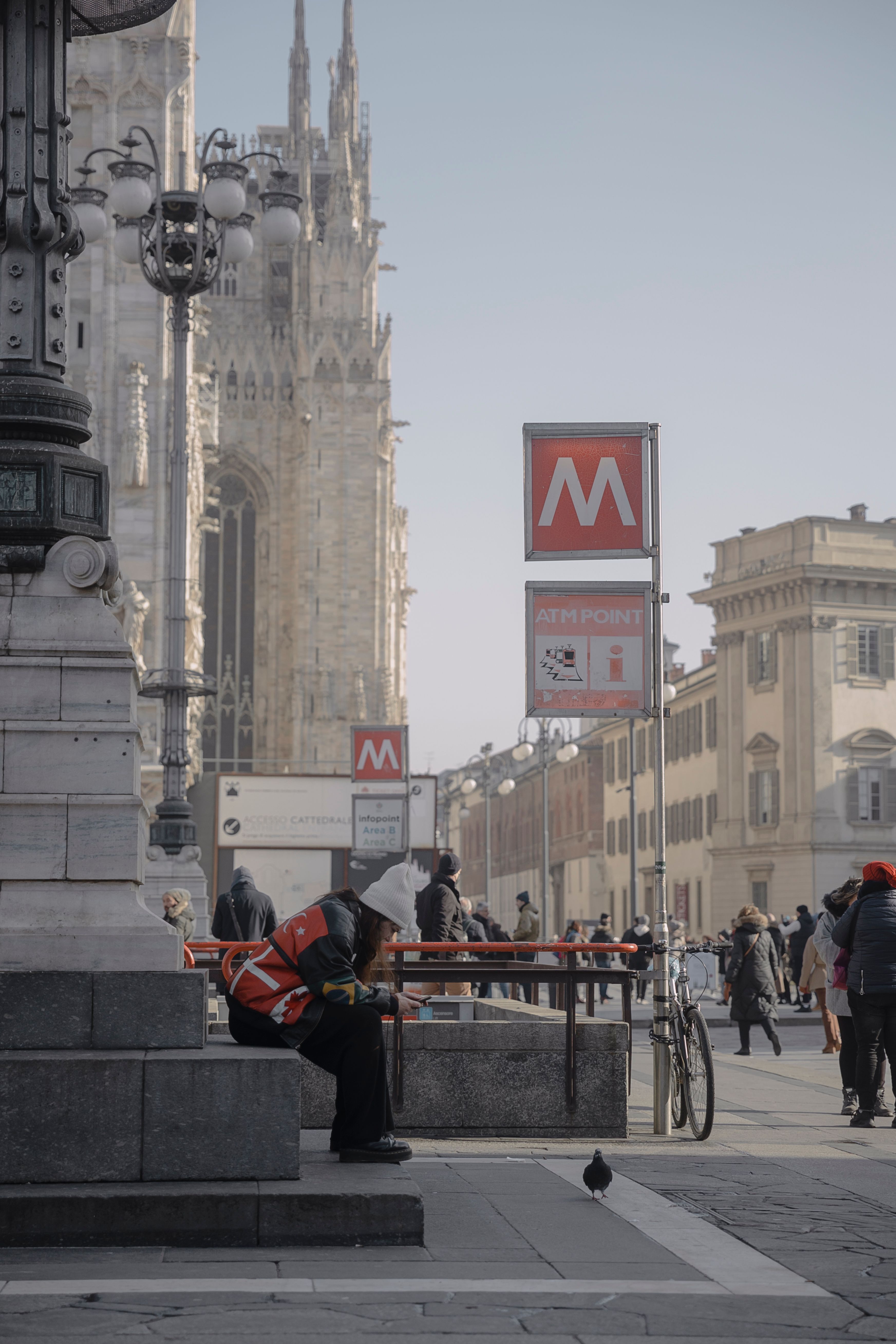 Street scene in Milan featuring the iconic Duomo di Milano and city life.