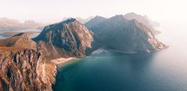 Discover the breathtaking aerial view of Ryten mountains and pristine beaches in Lofoten, Norway at sunrise.