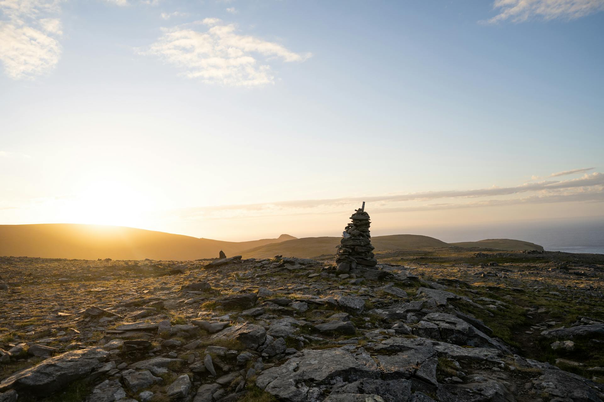 View of a Large Cairn on a Rocky Beach at Sunset