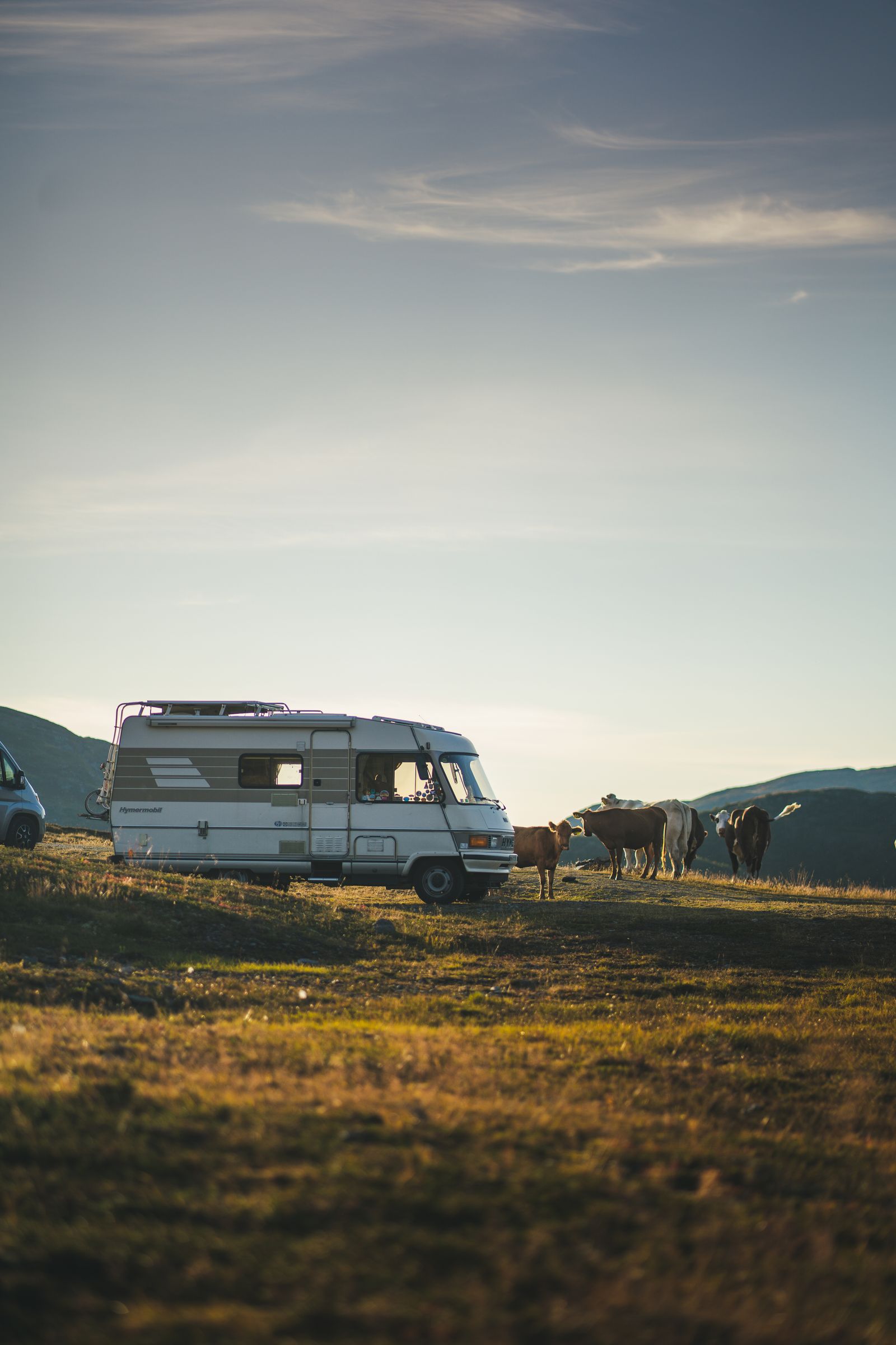 Campervan parked in open countryside with mountains in the distance