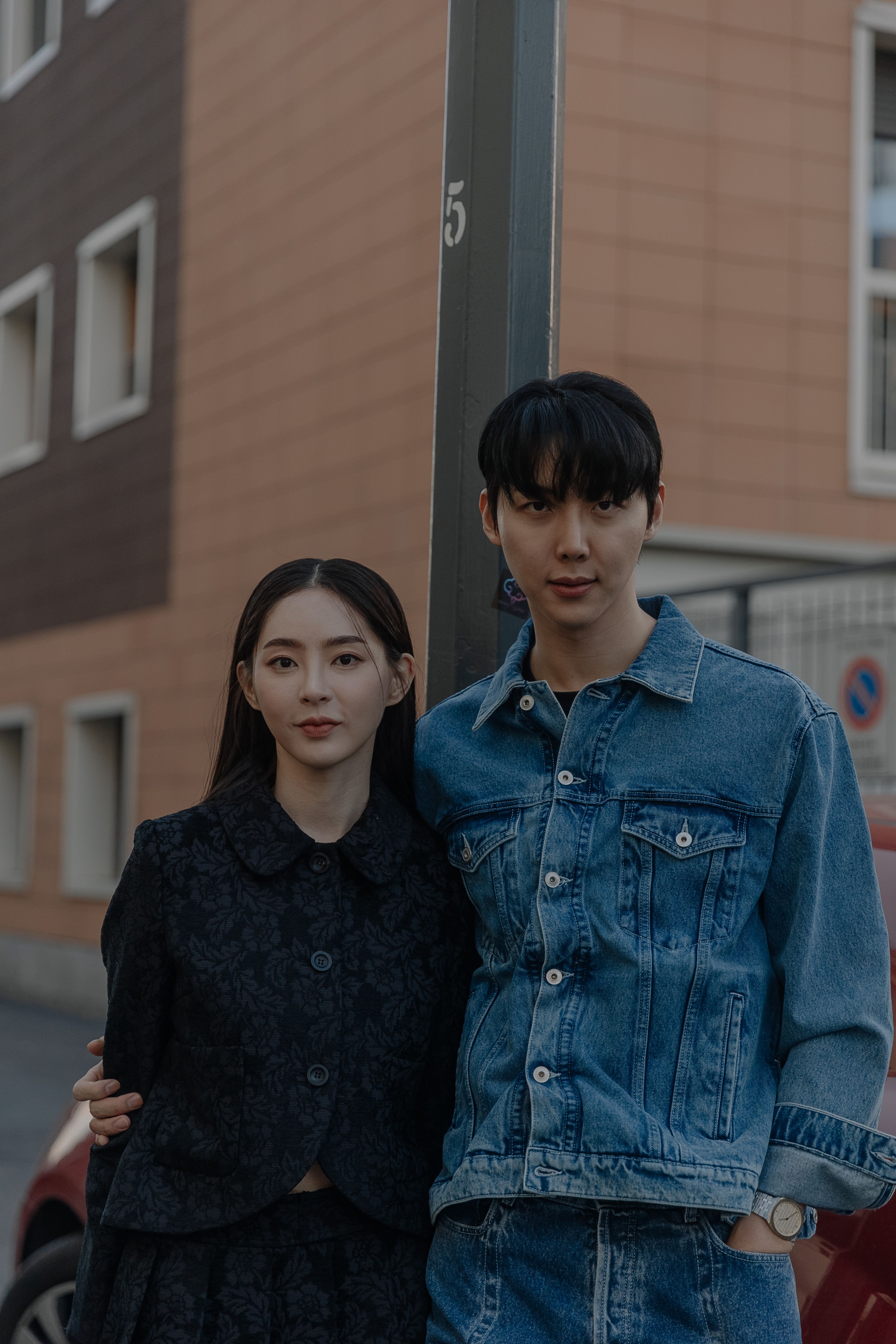 Fashionable couple posing in Milan. Stylish urban scene with denim and modern outfits.
