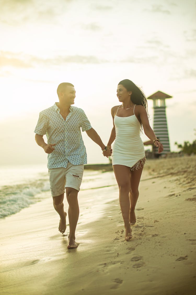 A Couple Running On The Beach