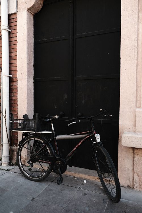 Free Classic bicycle leaning against a textured urban wall, perfect for city lifestyle themes. Stock Photo