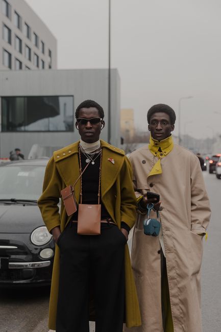 Two stylish men in Milan showcasing modern street fashion against an urban backdrop.