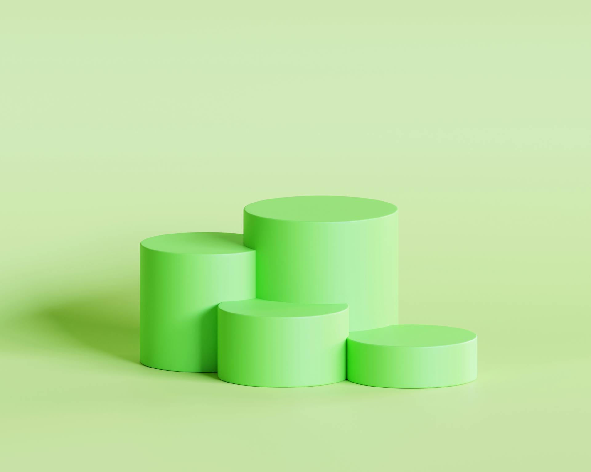 Abstract green podium with cylindrical shapes for showcasing products in a minimalist design.