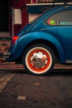 A classic blue Volkswagen Beetle parked on colorful streets of Istanbul.