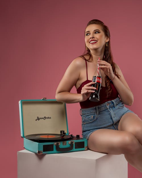 Smiling Brunette Woman in Red Top Sitting by Turntable