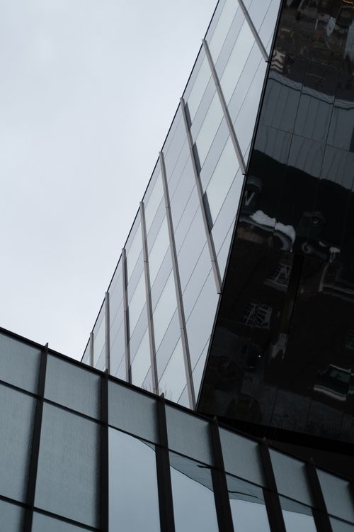 Free Sleek glass facade reflecting the urban environment in a modern architectural style. Stock Photo