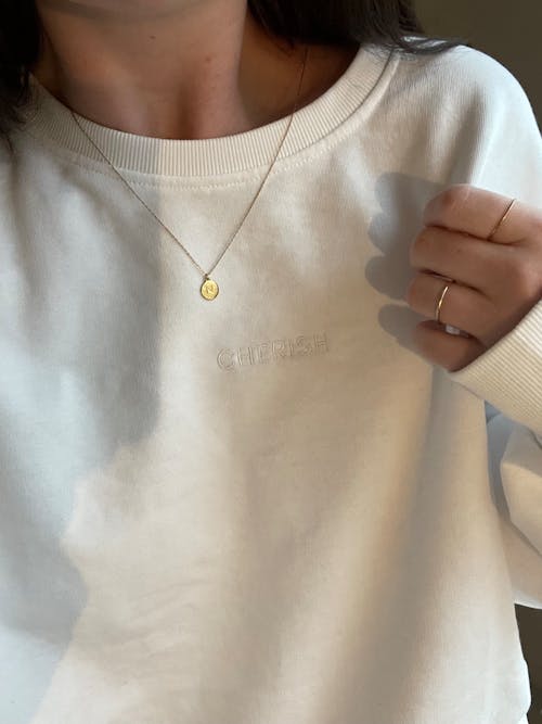 Golden Necklace on Woman in White Sweatshirt