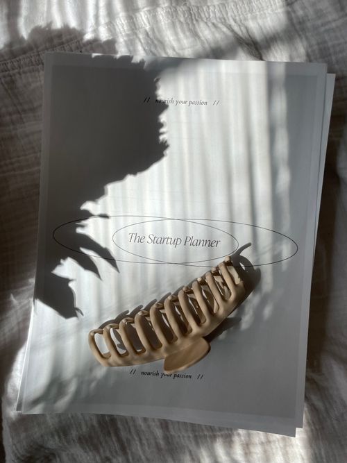 Free A startup planner with a hair clip in soft lighting, ideal for business and planning themes. Stock Photo
