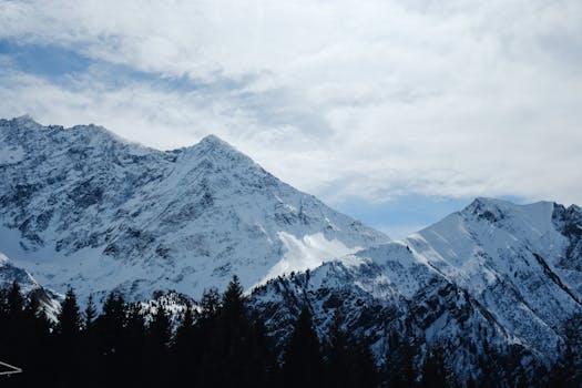 Breathtaking view of snow-laden mountains under a cloudy winter sky.