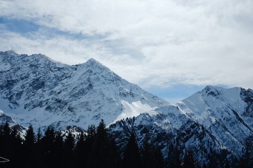 Free Breathtaking view of snow-laden mountains under a cloudy winter sky. Stock Photo