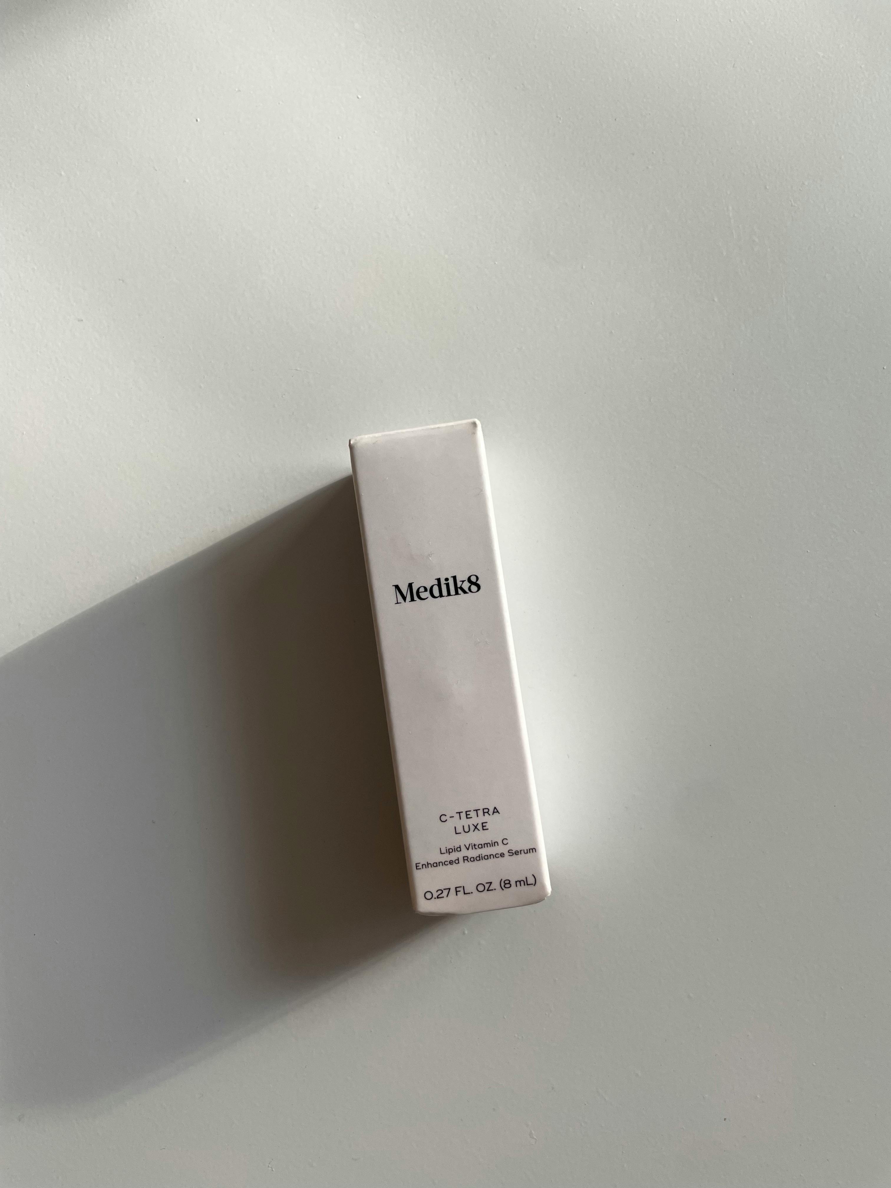 Elegant minimalist presentation of Medk8 skincare packaging with soft shadow contrast.