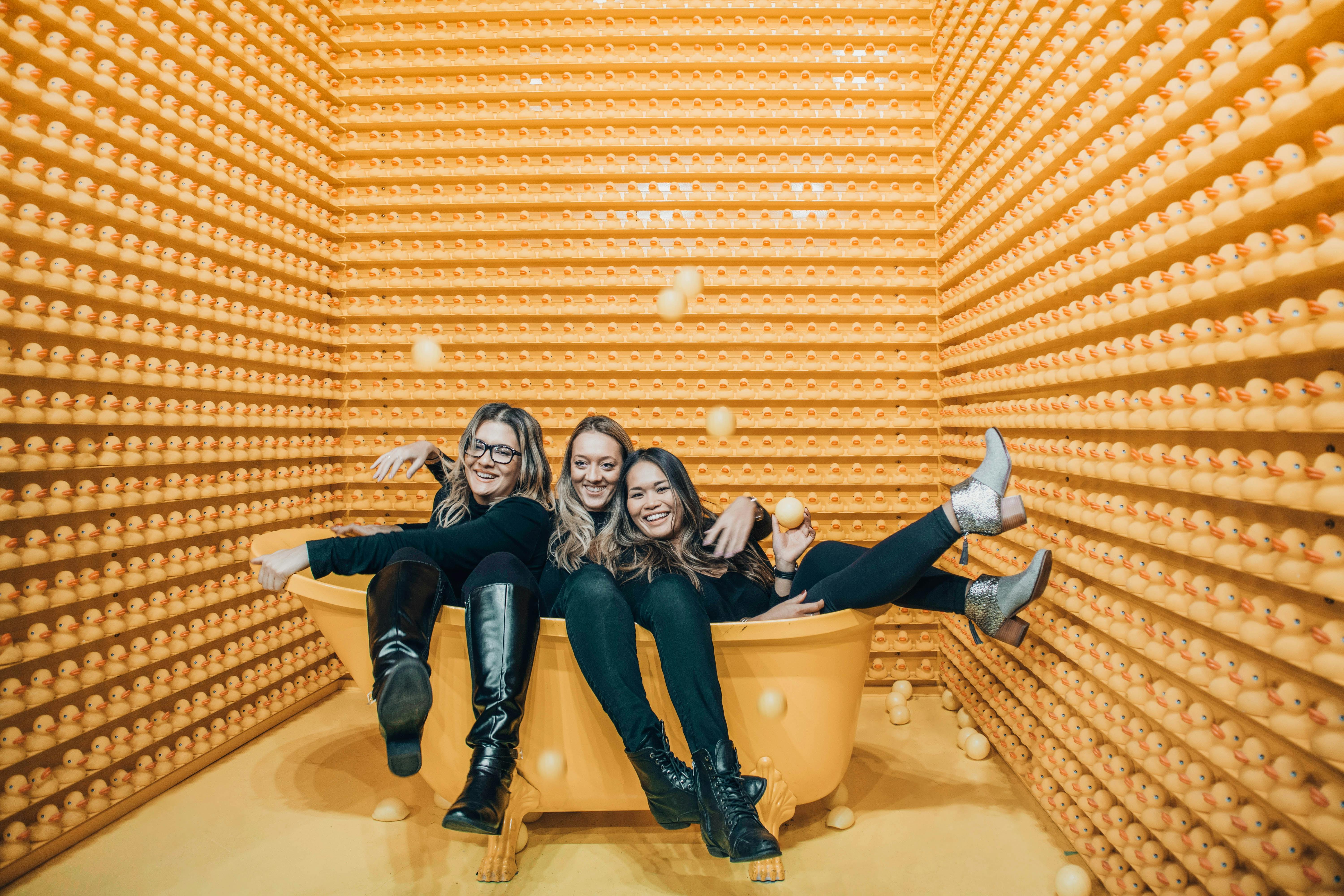 women sitting inside bathtub