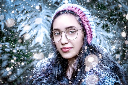 Woman Posing in Hat and Eyeglasses under Snowfall