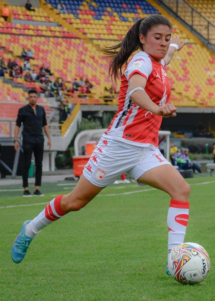 Woman Playing Football On Stadium