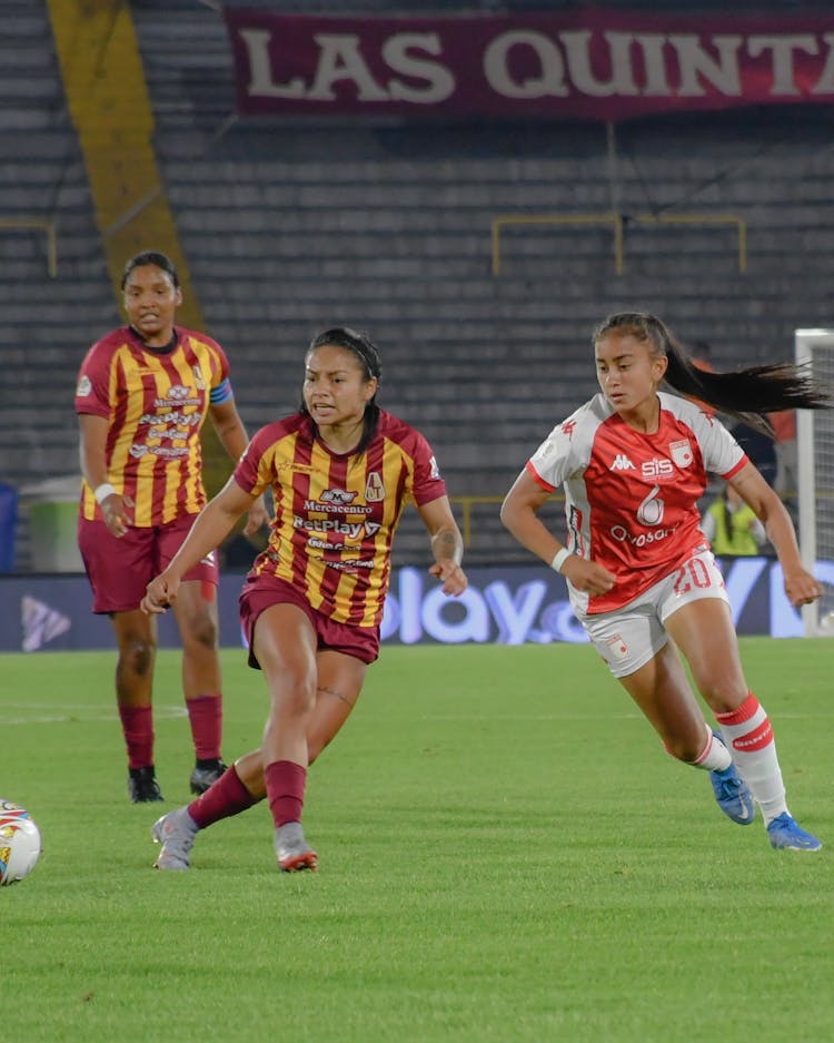 Women Playing Football On Stadium