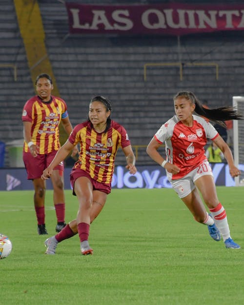 Free Women Playing Football on Stadium Stock Photo