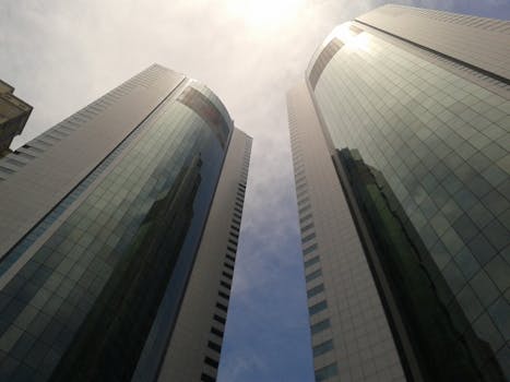 Pair of modern skyscrapers with reflective glass facade towering in Dubai under a clear sky.