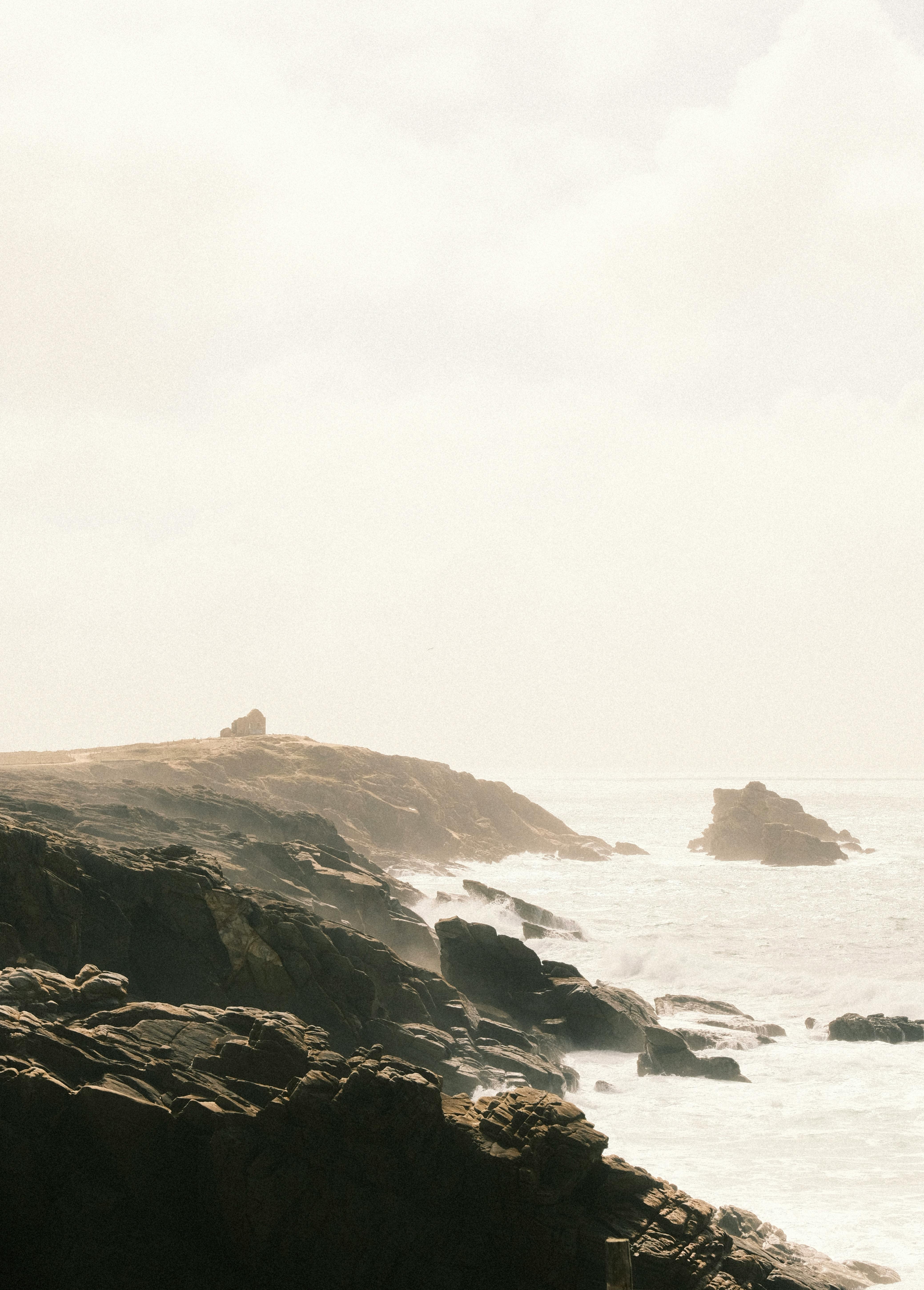 A stunning view of eroded rocks along a rugged coast bathed in sunlight, showcasing natural beauty and erosion.