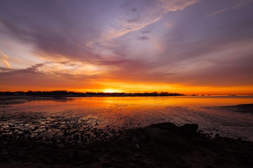 Free A breathtaking sunrise paints the sky in vibrant hues over a tranquil seascape, reflecting on the water. Stock Photo