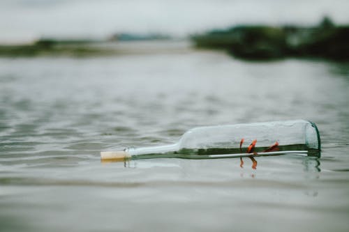 Gratis Foto De Enfoque Selectivo De Botella Flotando Sobre El Cuerpo De Agua Foto de stock