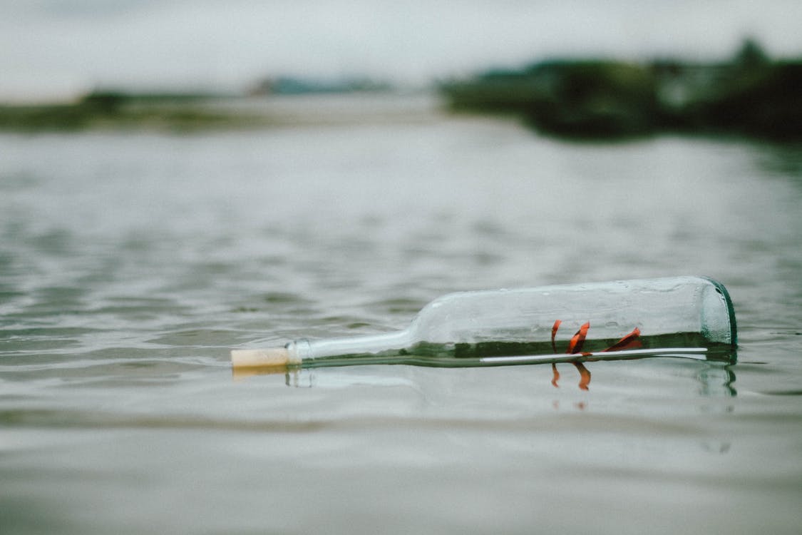 Selective Focus Photo Of Bottle Floating On Body Of Water