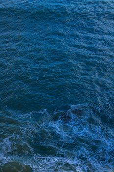 A tranquil view of ocean waves with deep blue tones and gentle motion.