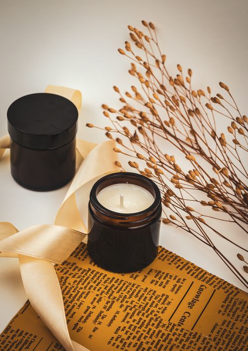 Free Aesthetic composition of candles and dried leaves on a vintage paper backdrop. Stock Photo