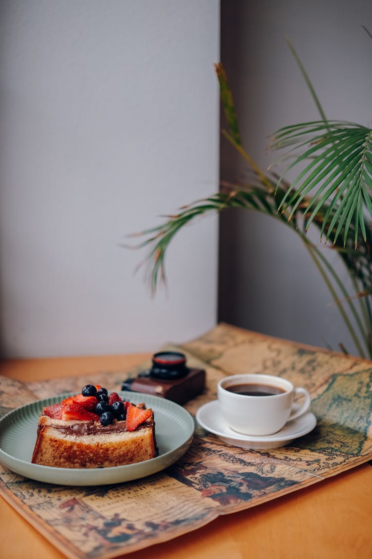 Black Coffee And Toast With Fruits On Table